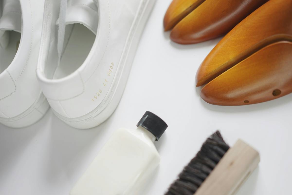 Premium sneaker cleaning kits laid out beside designer sneakers on marble surface